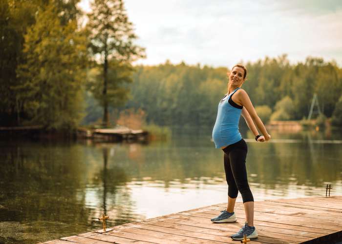 Stay healthy during pregnancy to lower the risks of having a child with ADHD: pregnant woman doing sport outdoor.