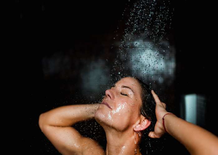 Take a shower when you get back home to prevent Lyme disease: woman taking shower.