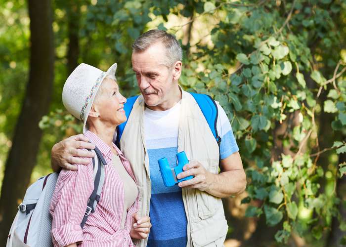Begin early retirement for Alzheimer: senior couple walking outdoor, enjoying their time.