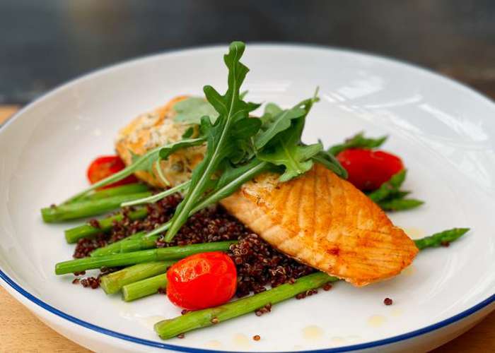 Healthy food for ADHD: Salmon and kinoa, with vegetables in a plate.