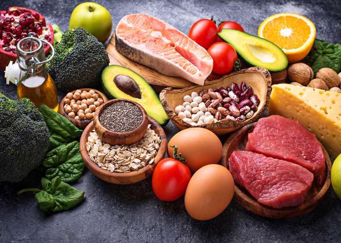 Eat nutrient rich organic food for cancer: food include meat, eggs, grains, avocado, salmon, olive oil, orange, and broccoli.