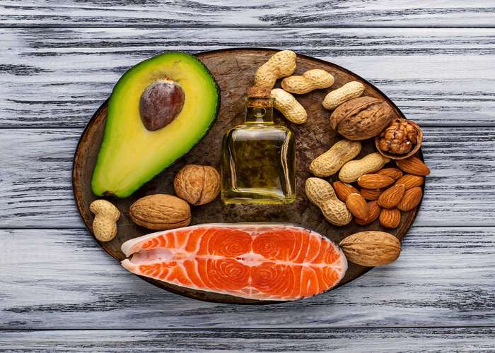 Consume omega-3 for arthritis: plate of salmon, avocado, and nuts, rich in omega-3.
