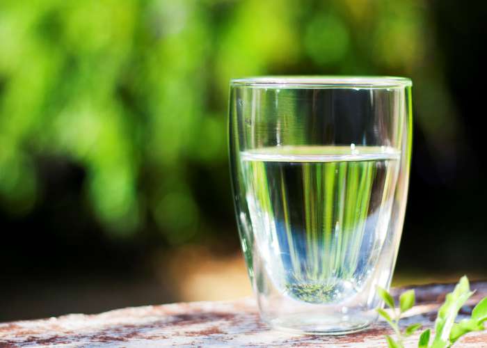 Drink water to stay hydrated: clean crystal drinking water in a glass.