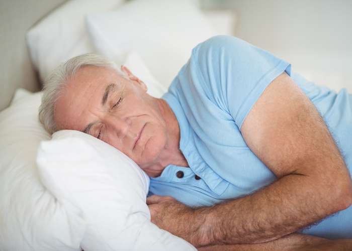 Sleep well for Parkinson: senior woman sleeping in bed.