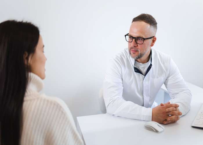 Female listening to her therapist and discussing her condition with him in the doctor clinic.