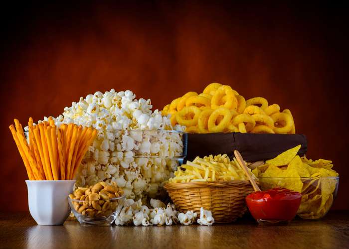 Avoid junk foods for ADHD: selection of junk foods including chips, popcorn, and salty sticks.
