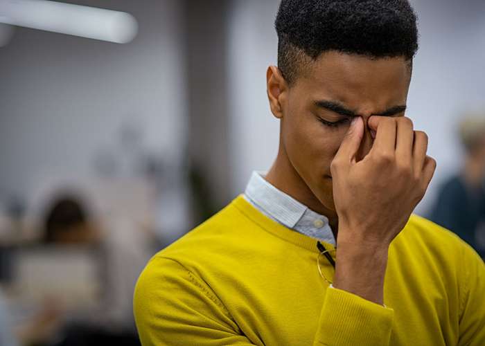 Avoid stress for ADHD: stressed man thinking with his hand on his face.