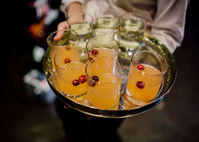 Restrict alcohol intake for heart disease because it damages the arteries: tray full of orange alcoholic drinks.