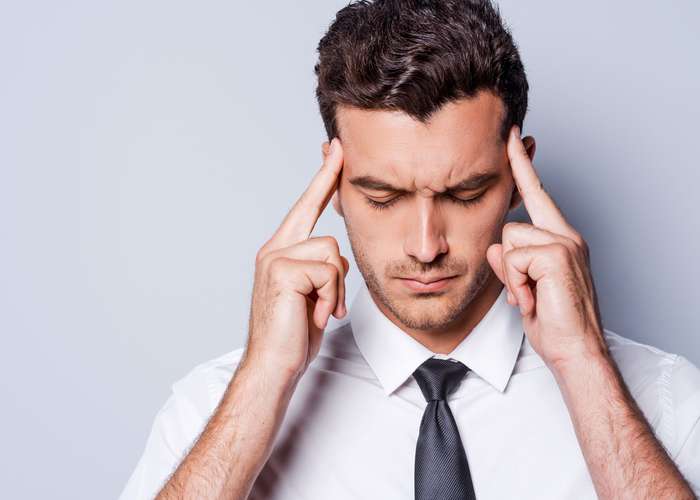 Avoid stress for heart disease: stressed man, thinking and putting his fingers on his head temples.