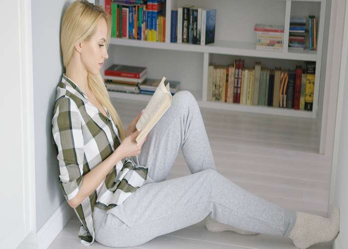 Avoid sitting on hard surfaces for hemorrhoids: woman sitting on the floor.