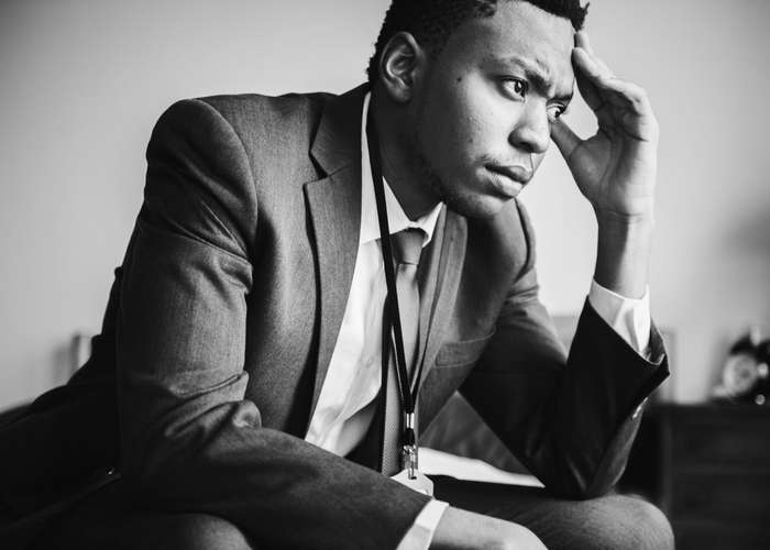 Avoid stress for IBS: stressed man thinking with his hand on his forehead.