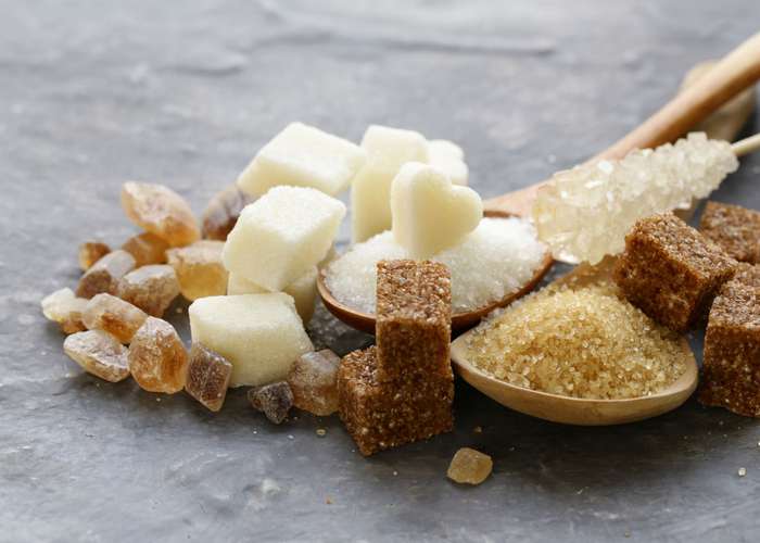 Avoid sugar for Parkinson: different kinds of sugar including brown sugar, sugar cubes, and white sugar grains.