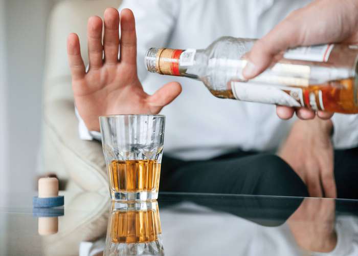 Avoid alcohol consumption: man rejecting alcohol and showing sign of having enough alcohol
