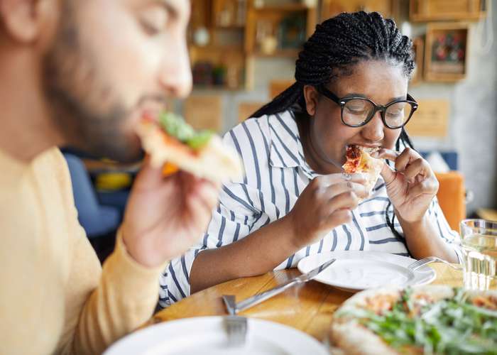 Eating quickly is bad for digestion: woman eating pizza fast