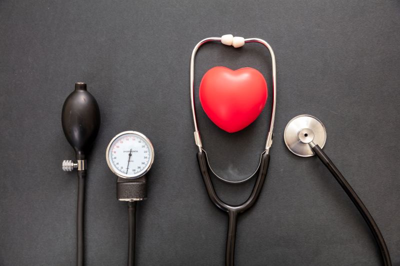 Man holding his heart with pain symptoms showing. He suffers from heart disease or having a heart attack or heart burn.