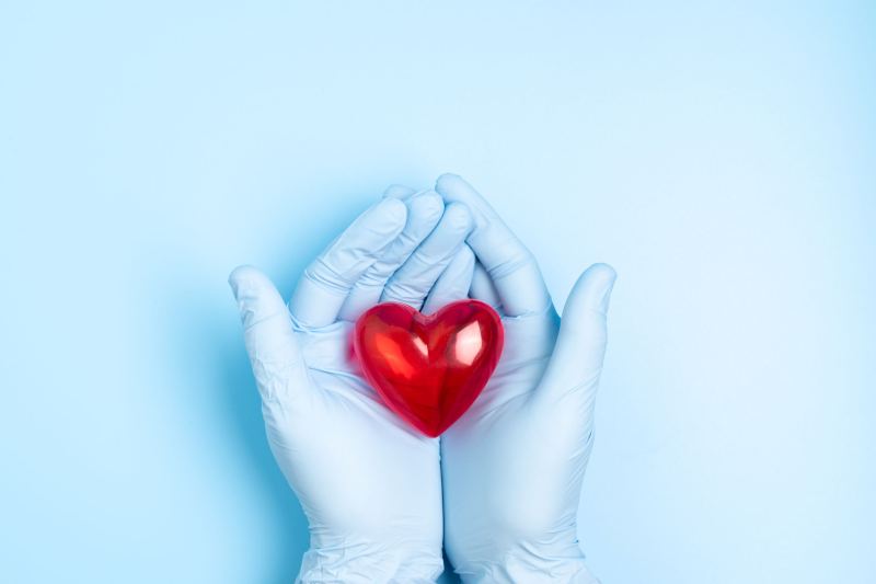 Man holding his heart with pain symptoms showing. He suffers from heart disease or having a heart attack or heart burn.