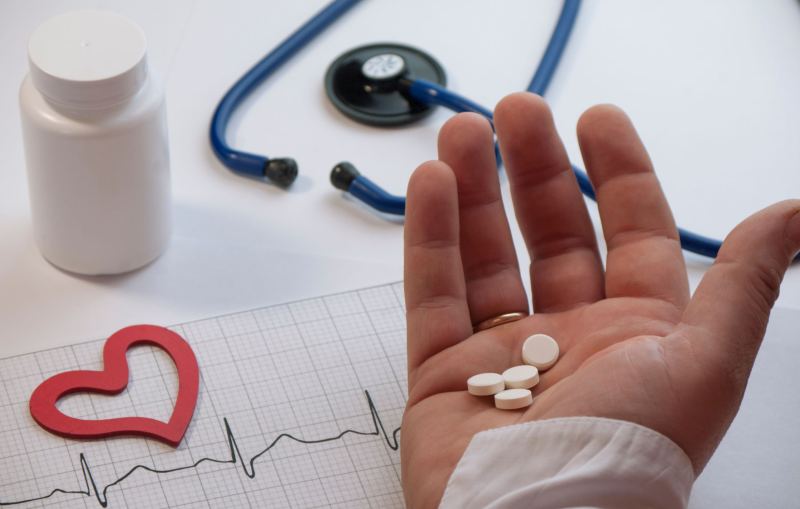 Man holding his heart with pain symptoms showing. He suffers from heart disease or having a heart attack or heart burn.